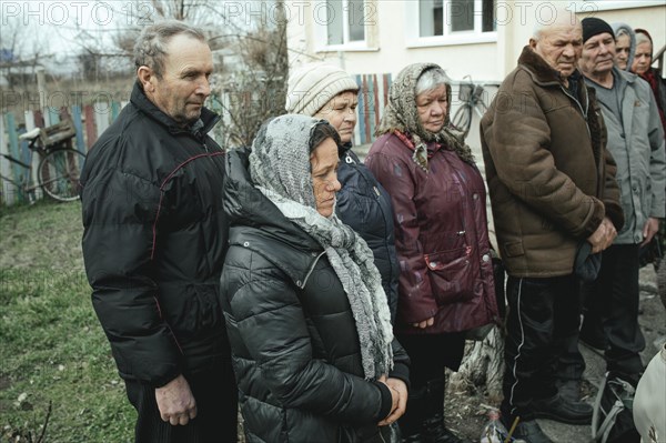 Worshippers receive the blessing of water on the day of the Epiphany and drink in the courtyard of the village school