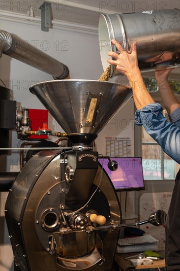 Green coffee is poured into the roasting machine