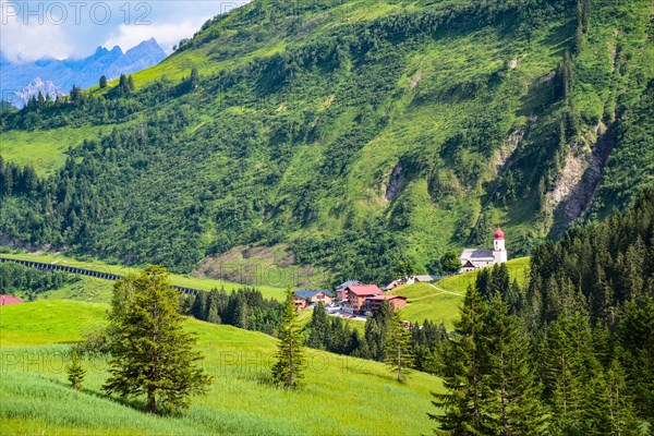View of Damuels and the village church of Sankt Nikolaus in the Bregenzerwald in the background the Rote Wand