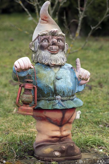 Garden gnome with lantern in a garden