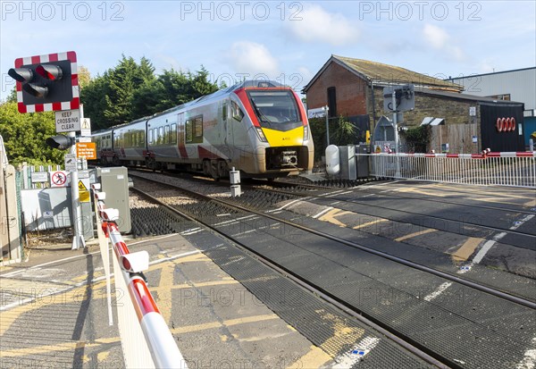 Abellio Greater Anglia Class 755 Stadler bi-modal train at level crossing