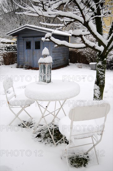 Garden table with chairs under a blanket of snow in winter