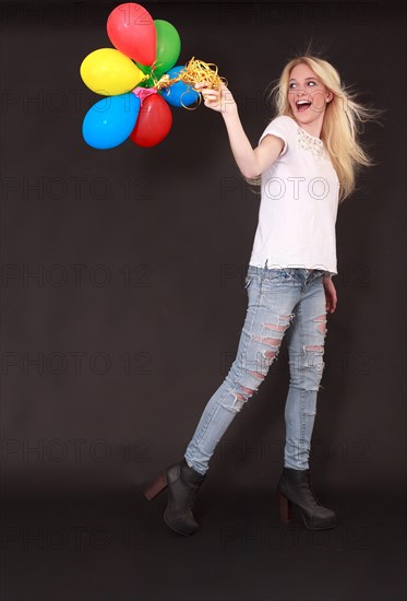 Young woman with different coloured balloons