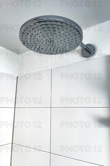 Running water from in shower with large shower head type rain shower with high water consumption