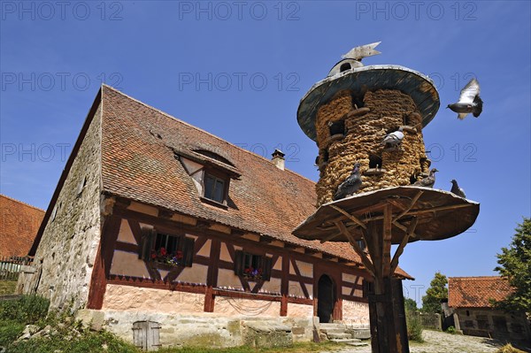 Straw-woven dovecote from 1895 behind farmhouse from 1684