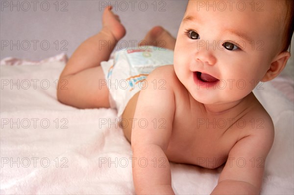 Smiling baby girl wearing a diaper