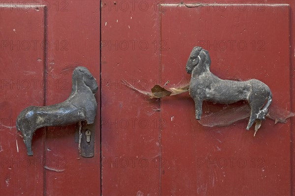 Old horse figures as door handles on a door of a former Cistercian monastery