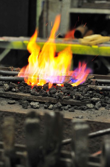 Glowing iron in glowing coal in a forging forge