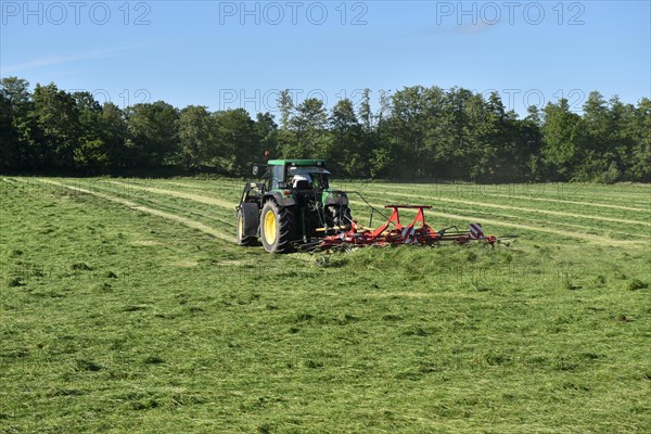 Tractor with hay tedder