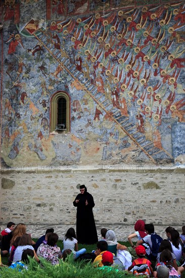 Nun explains the fresco painting Ladder to Heaven to a school class