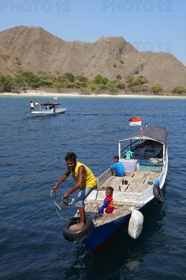 Man on fishing boat at sea with children