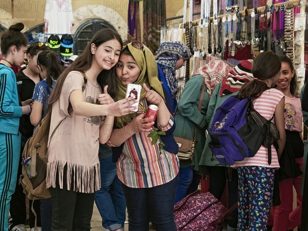 Shopping in a market: two young schoolgirls