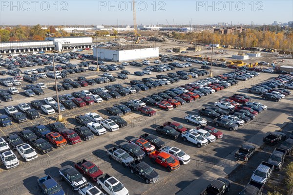 Ford pickup trucks are parked in a vacant warehouse parking lot