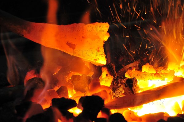 Glowing iron in glowing coal in a forging forge