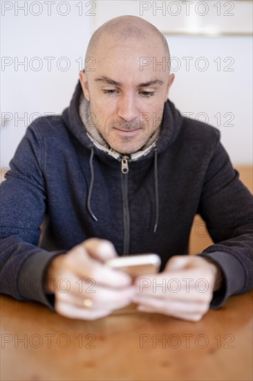 Man sitting at the table looking at his mobile phone