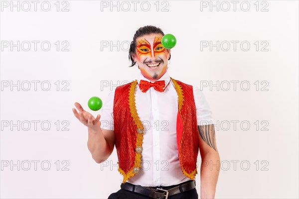 Smiling juggler juggling green balls isolated on white background