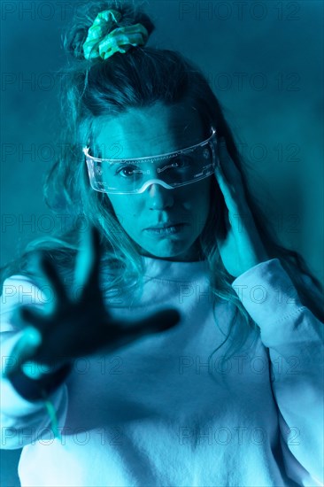 Woman with futuristic glasses gesturing against a blue background