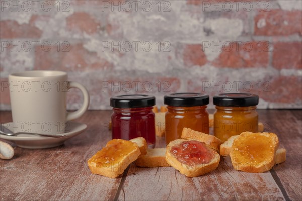 Toasted bread with jam and a cup of coffee on a wooden table