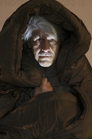 Elderly gentleman freezing in sleeping bag