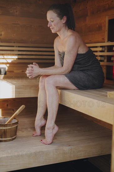 Woman sitting in Finnish sauna