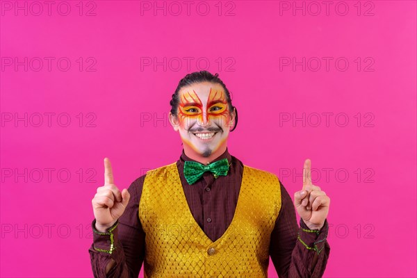 Clown with white face makeup showing empty space on pink background