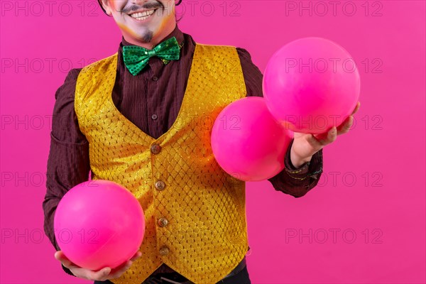 Clown with white facial makeup on a pink background