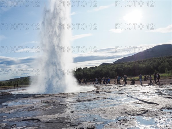 Tourists watching a geyser erupt