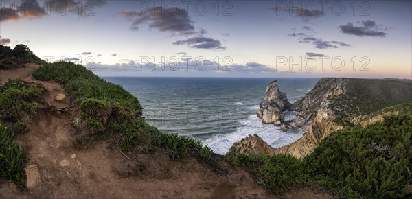 Sunset on the cliff with rocks in the sea