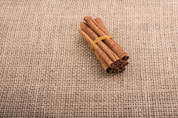 Bundle of cinnamon sticks on a linen canvas background