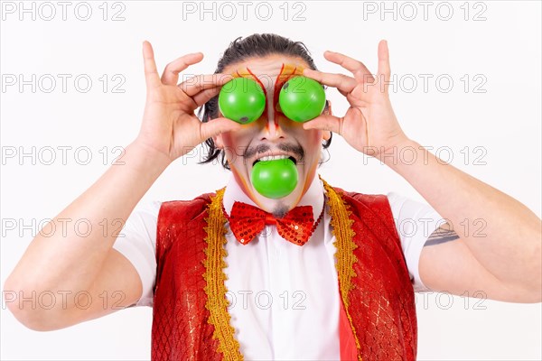 Portrait of smiling juggler juggling green balls isolated on white background