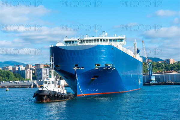 Cargo ship transporting a giant ship in the bay of Pasaia to the open sea Pasajes