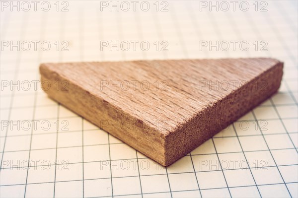 Piece of wood in the shpae of a triangle on paper