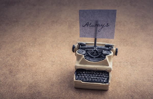 Retro syled tiny typewriter model on a brown background