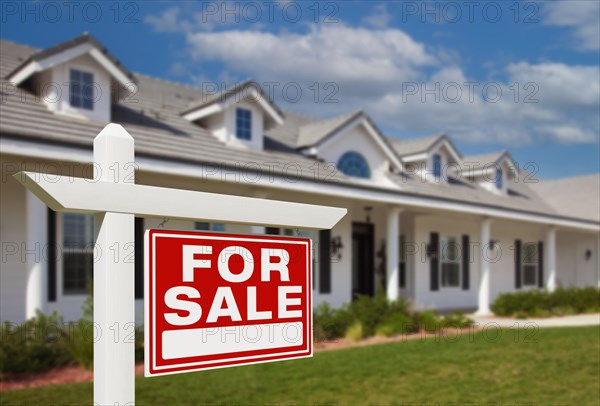 For sale real estate sign in front of new house