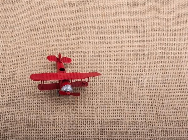 Toy airplane on a linen canvas background