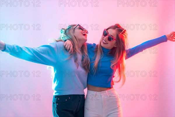 Two young blonde caucasian women dancing in disco