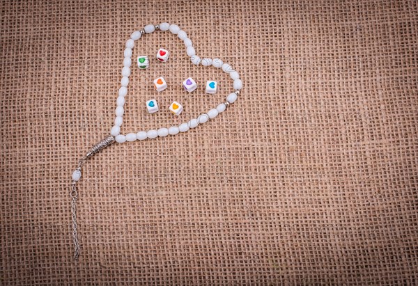 Heart shaped cubes in hand by inside a praying beads