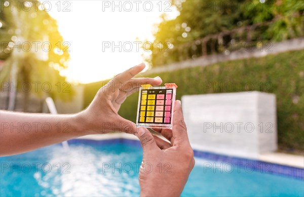 Hand holding a pool ph and chlorine tester