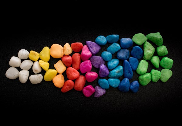 Pile of little colorful pebbles on black background