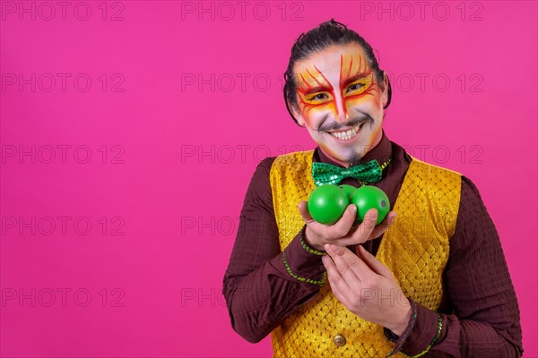 Clown with white facial makeup on a pink background