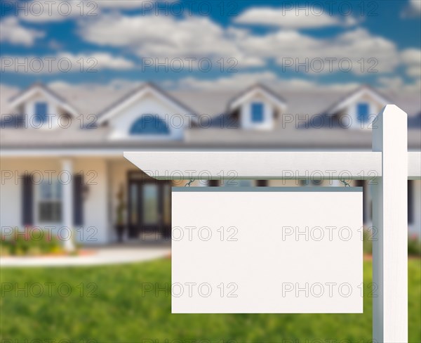 Blank real estate sign in front of new house