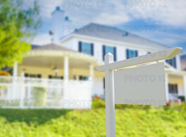 Blank real estate sign in front of new house