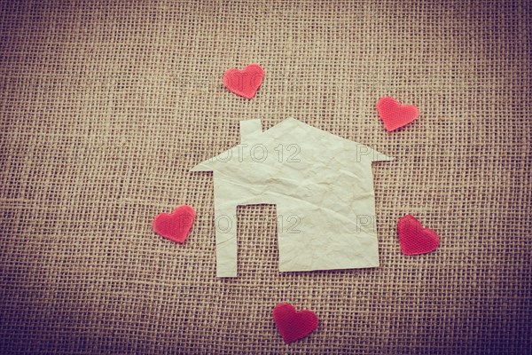 Heart shape around the paper house with a canvas background