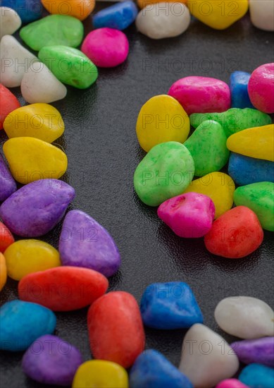 Pile of little colorful pebbles on black background