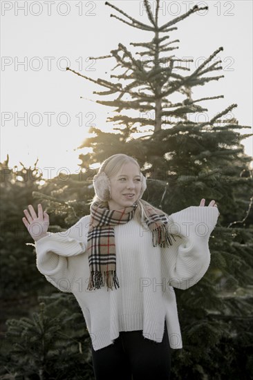 Teenage girl in front of fir trees