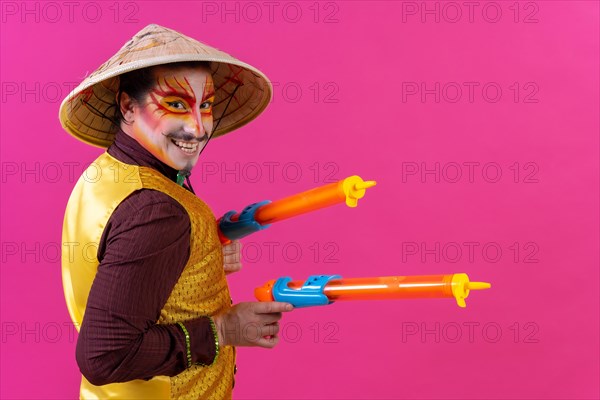 Clown with white facial makeup on a pink background