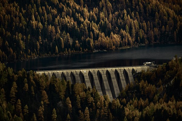 Dam of the Zufrittsee with autumnal mountain forest