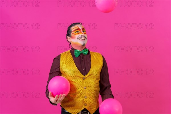 Clown with white facial makeup on a pink background