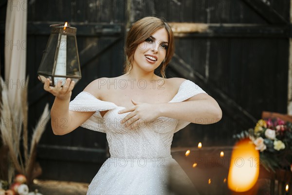Portrait of beautiful bride holding lantern in rustic background