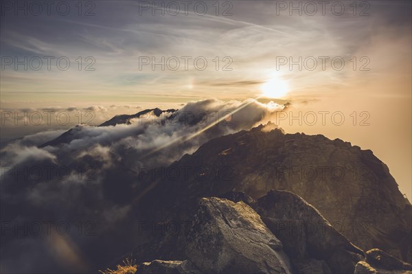 The rising sun illuminates the mountainous landscape